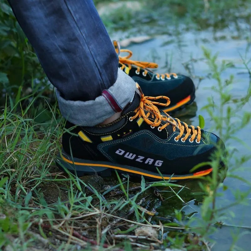 Chaussures de randonnée basses pour homme portées sur un terrain naturel herbeux. Ce modèle assure une bonne accroche et un bon maintien lors de la marche.