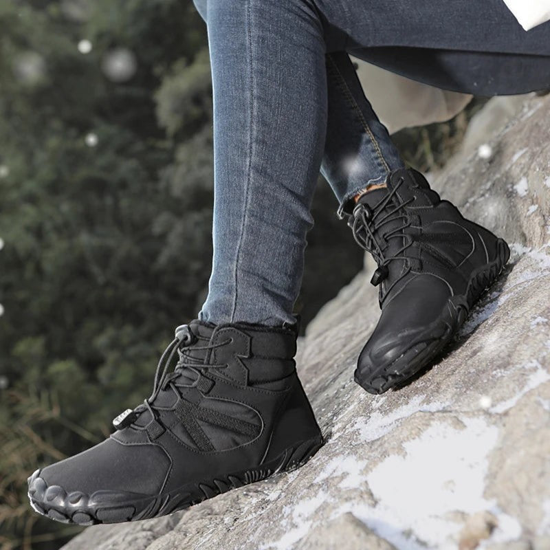 Chaussures de randonnée hiver femme utilisées sur rocher avec bonne adhérence et maintien du pied.
