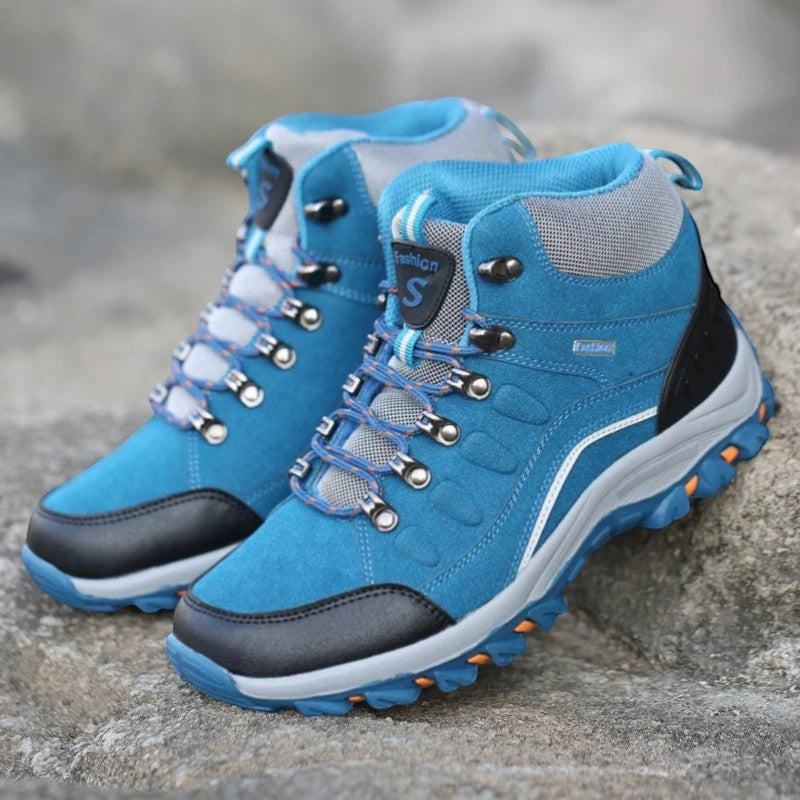 Chaussures de randonnée hiver femme bleu sur terrain rocheux avec bonne adhérence et stabilité.