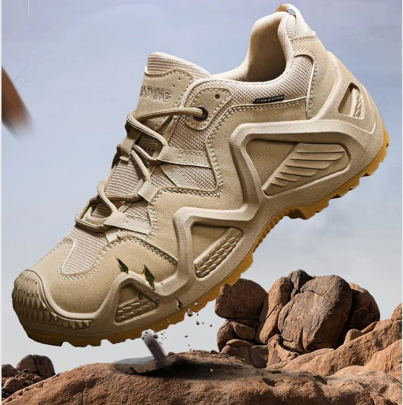 Chaussures de randonnée basses pour homme en beige en action sur un terrain rocheux. Ce modèle dispose d’une semelle crantée assurant une bonne adhérence et une excellente stabilité.