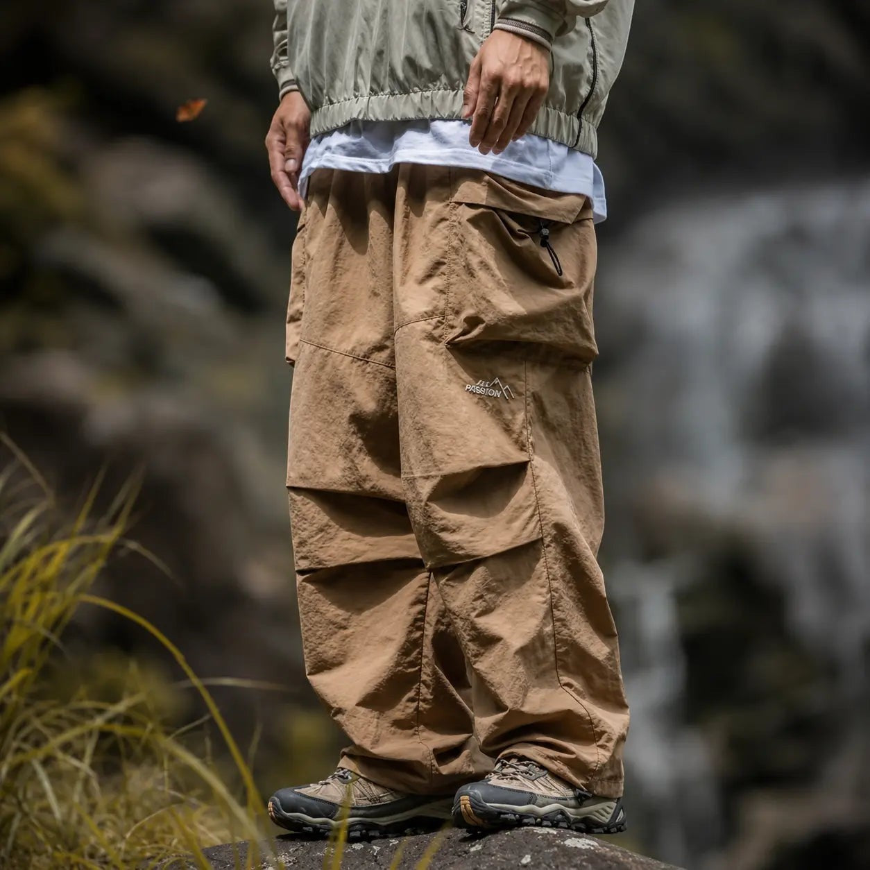 Détail d’un pantalon de randonnée beige Passion Randonnée avec jambes larges, tissu léger et poches cargo pour un usage outdoor.