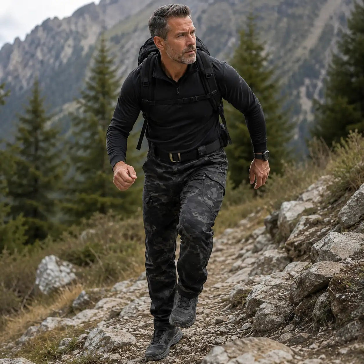 Homme en mouvement avec un pantalon de randonnée camouflage noir Passion Randonnée, idéal pour la marche, le trekking et les sorties outdoor.