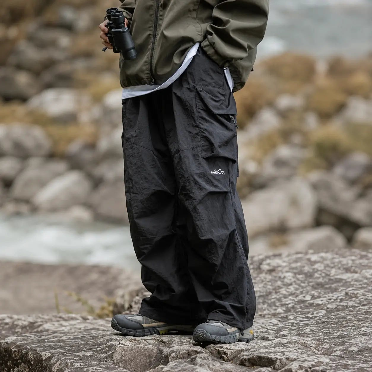 Vue rapprochée d’un pantalon de randonnée noir Passion Randonnée, avec coupe large, poches cargo et style technique pour la marche.