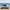 Tente de camping familiale automatique Passion Randonnée avec table et chaises sur une plage de sable.