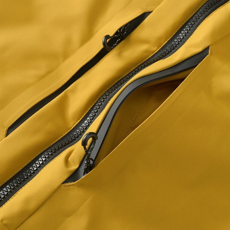 Détail de la fermeture zippée d’une veste femme jaune Passion Randonnée, avec poche poitrine pratique et tissu adapté aux sorties outdoor.