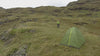 Vue aérienne d’un randonneur progressant dans les collines, avec un moment de repos en pleine nature, idéal pour illustrer la randonnée, le trekking et l’aventure outdoor.